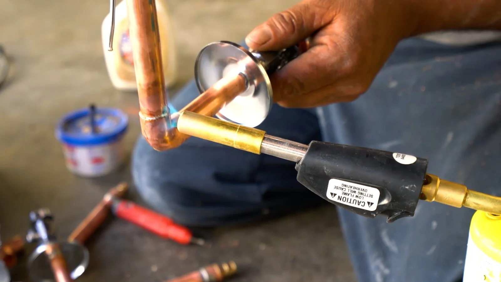 Technician soldering a copper water pipe connection