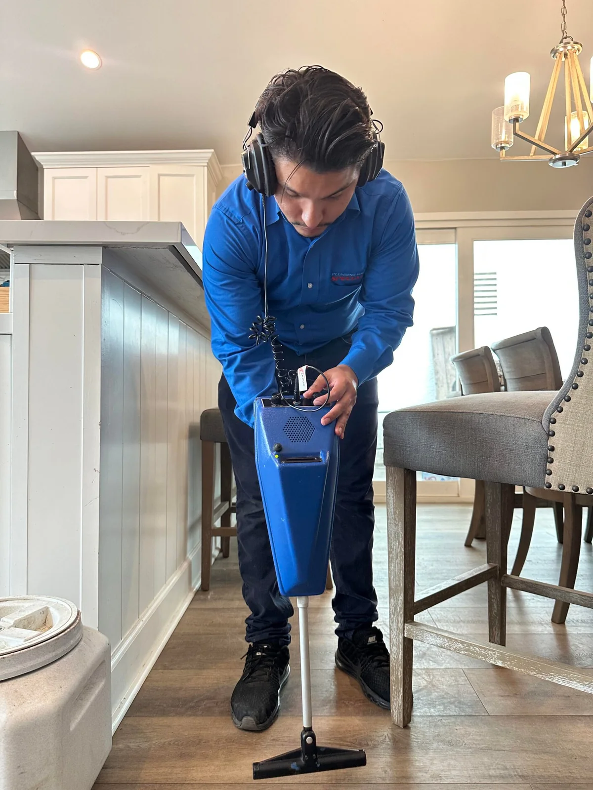 Technician tracing the source of a hidden running water sound