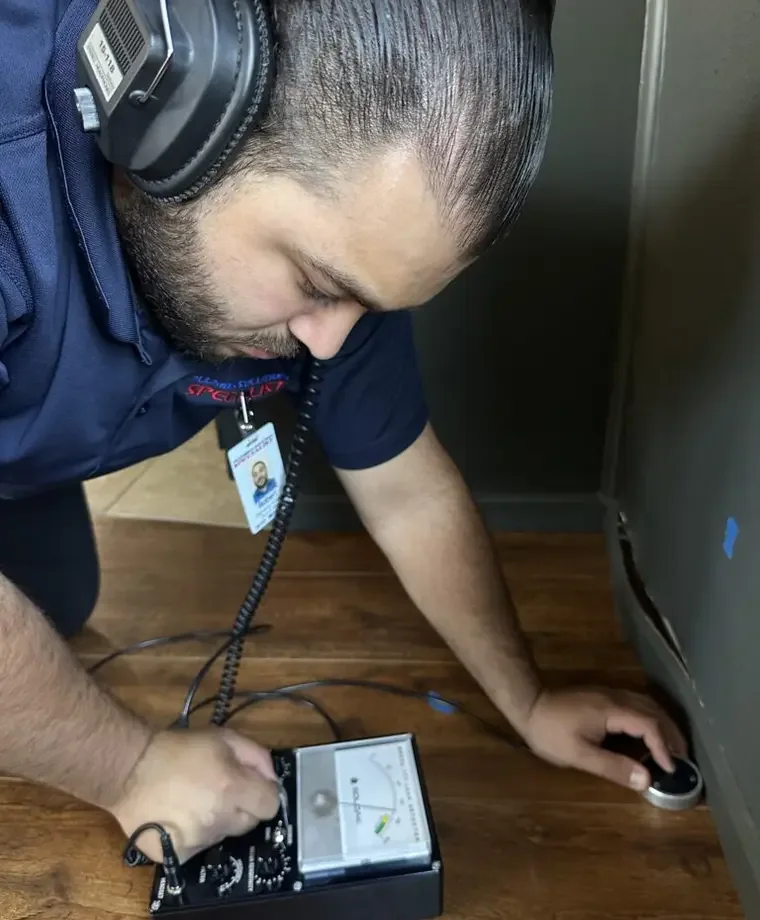 Technician listening for a concealed water leak