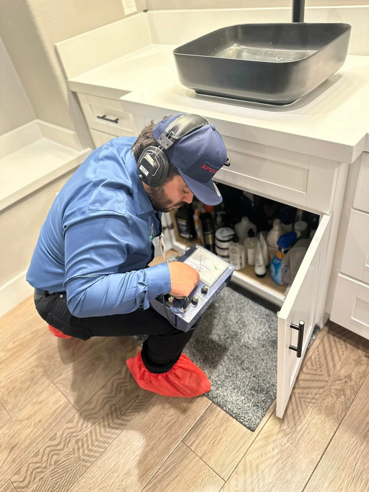 Technician using diagnostic equipment to locate a hidden leak
